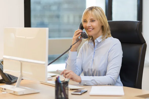 Empresária usando telefone no escritório — Fotografia de Stock