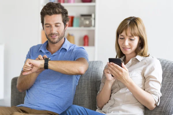 Digital Geek couple on sofa at home — стоковое фото