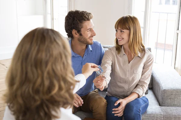 Onroerende goederenagent huis sleutels te geven aan nieuwe eigenaars — Stockfoto