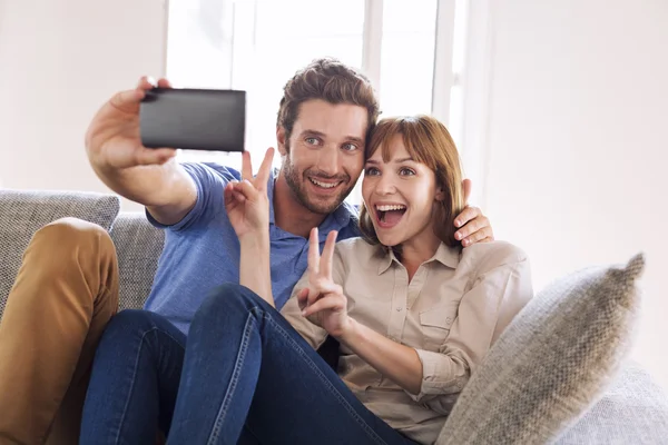 Feliz pareja divertida tomando una selfie con un teléfono móvil —  Fotos de Stock