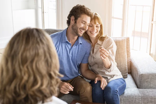 Saleswoman donnant des clés d'appartement aux nouveaux propriétaires Photo De Stock