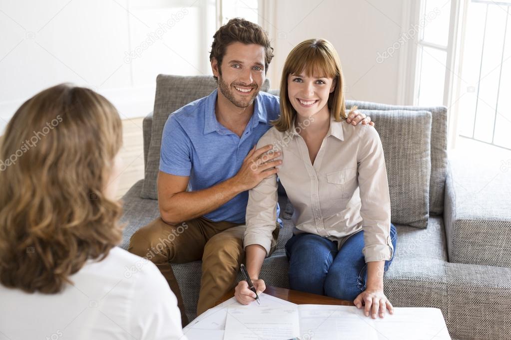 Young couple owners meeting real estate agent for house purcha