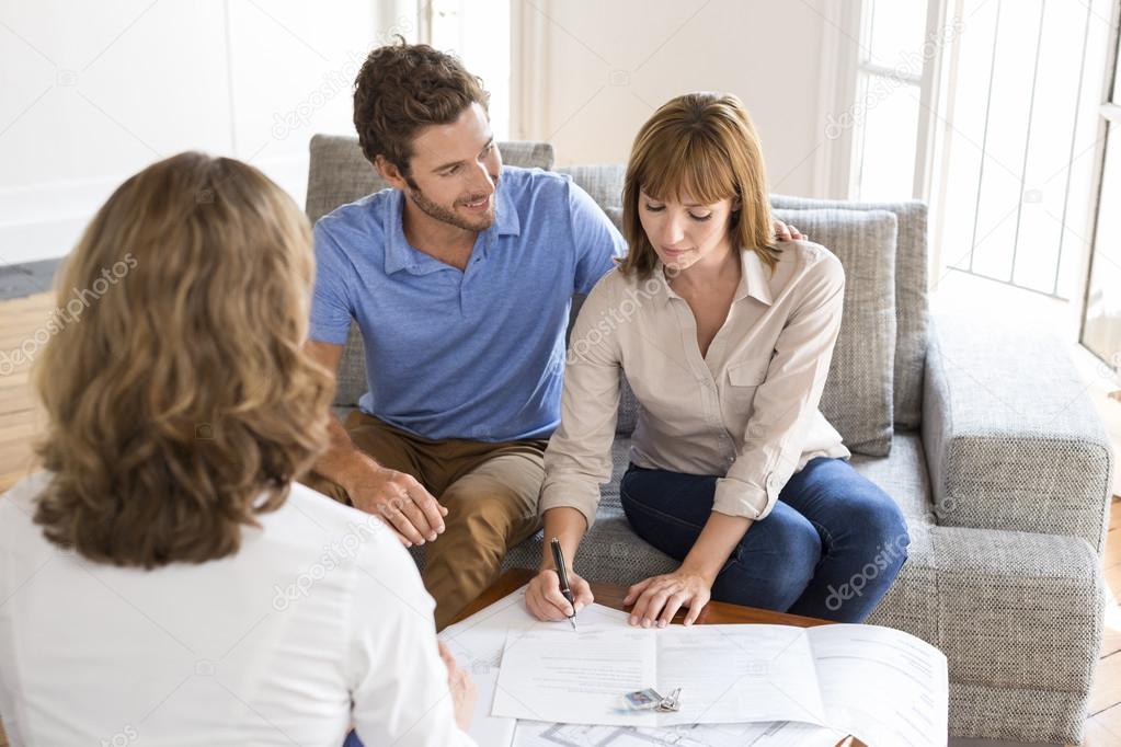 Owners couple signing a contract with real estate agent for house investmen