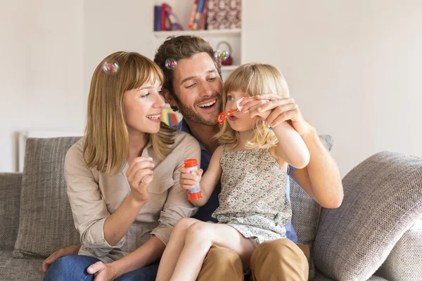 Vrolijke ouders en dochter bellen blazen in wit huis — Stockfoto