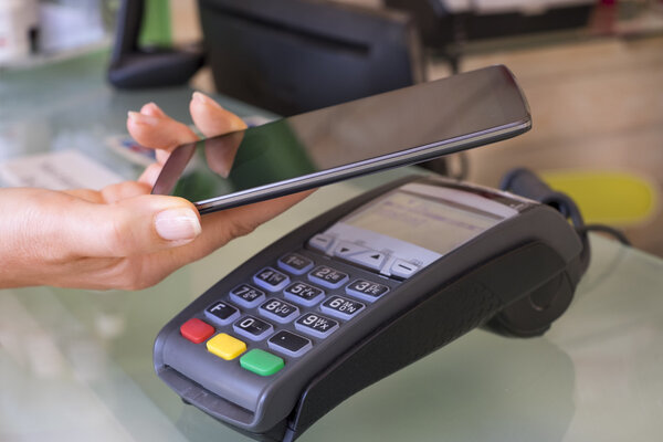 Woman paying with NFC technology on smartphone