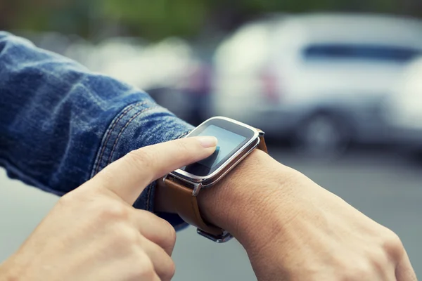 Woman looking for her car with smartwatch — Stock Photo, Image