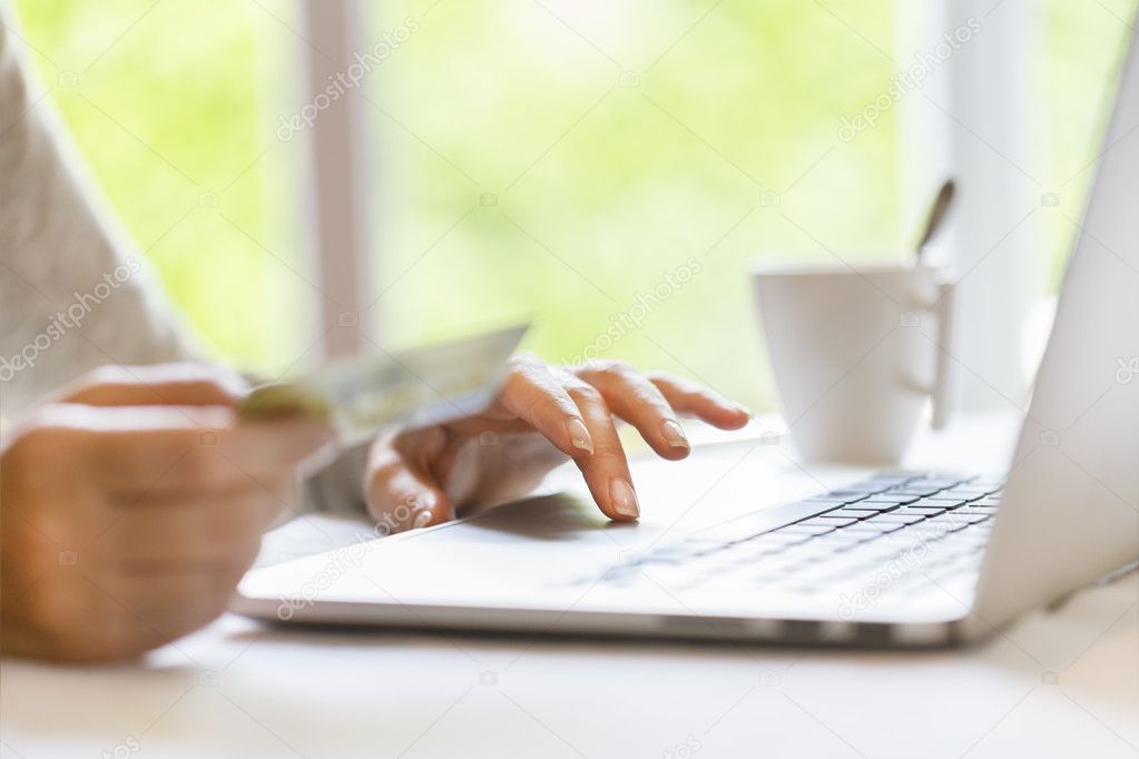 Woman using credit card and laptop