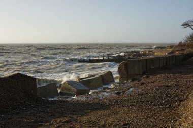 Littlehampton, West Sussex, İngiltere yakınlarındaki Climping 'de dalgalı dalgalı bir sahil. Kıyı savunmasında fırtına hasarı.