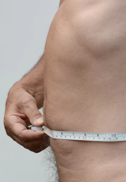 Byt Male žaludku v profilu s Svinovací metr — Stock fotografie