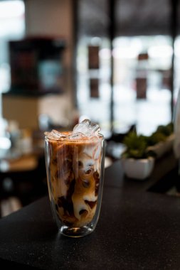 Yakın plan buzlu kahve. Masada süt var.
