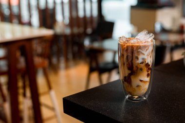 Yakın plan buzlu kahve. Masada süt var.