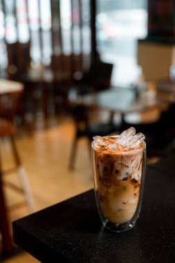 Yakın plan buzlu kahve. Masada süt var.