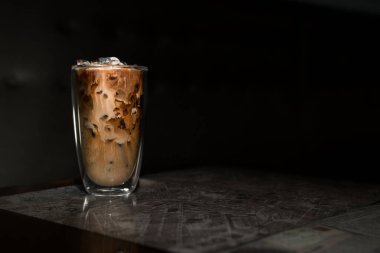 Yakın plan buzlu kahve. Masada süt var.