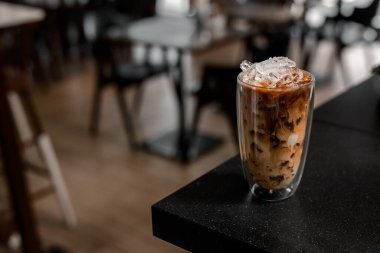 Yakın plan buzlu kahve. Masada süt var.