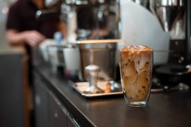 Yakın plan buzlu kahve. Masada süt var.