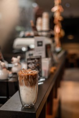 Yakın plan buzlu kahve. Masada süt var.