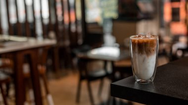 Yakın plan buzlu kahve. Masada süt var.