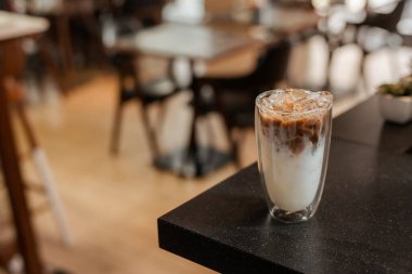 Yakın plan buzlu kahve. Masada süt var.