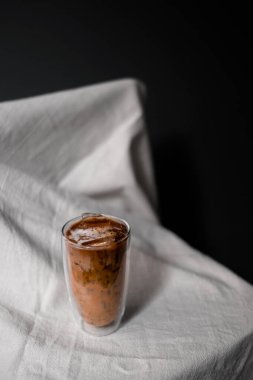 Yakın plan buzlu kahve. Masada süt var.