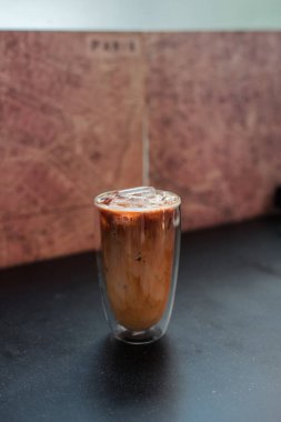 Yakın plan buzlu kahve. Masada süt var.