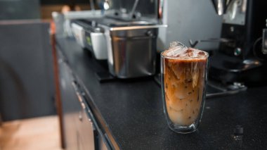 Yakın plan buzlu kahve. Masada süt var.