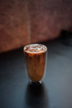 Yakın plan buzlu kahve. Masada süt var.