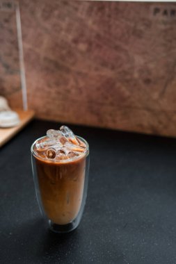 Yakın plan buzlu kahve. Masada süt var.