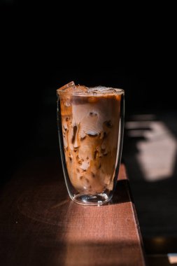 Yakın plan buzlu kahve. Masada süt var.