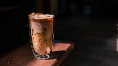 Yakın plan buzlu kahve. Masada süt var.