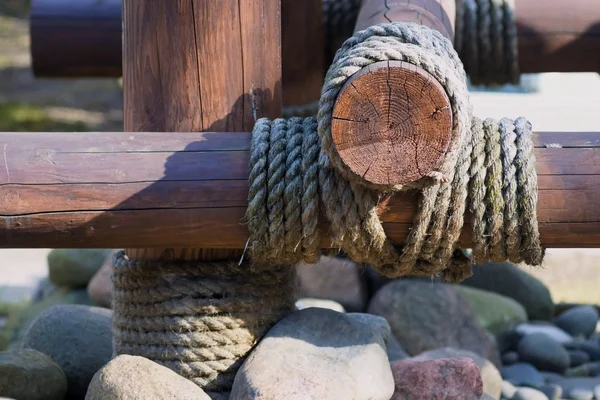 Konstruktion aus Holzstämmen wird mit einem Seil befestigt — Stockfoto