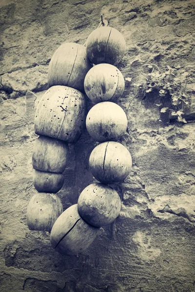 Old wooden beads on a stone wall — Stock Photo, Image