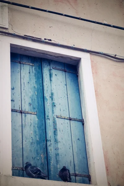 Fachada edificio antiguo con una ventana y persiana solar cerrada — Foto de Stock