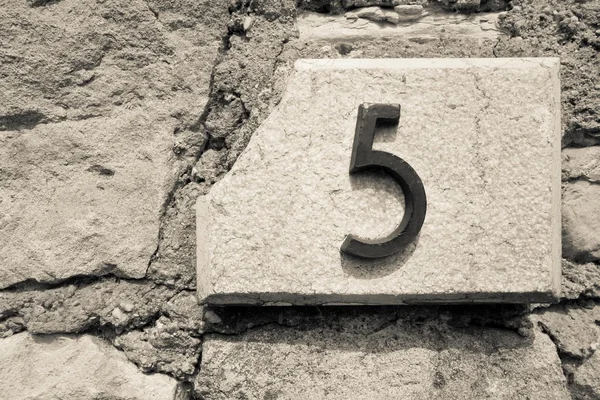 Siffran fem på en stenmur — Stockfoto