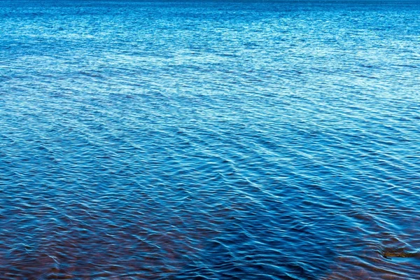 La gran superficie de agua texturizada de color azul brillante —  Fotos de Stock