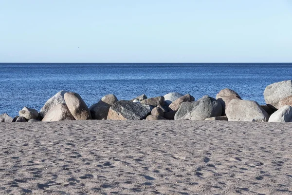 Sandstrand und große Steine an Land in Wassernähe — Stockfoto