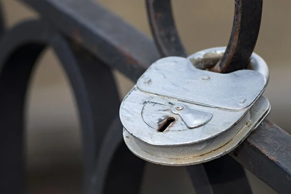 Oude zilveren hangslot op een ijzeren hek — Stockfoto