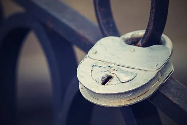 Padlock on an iron fence with a retro effect — Stock Photo, Image