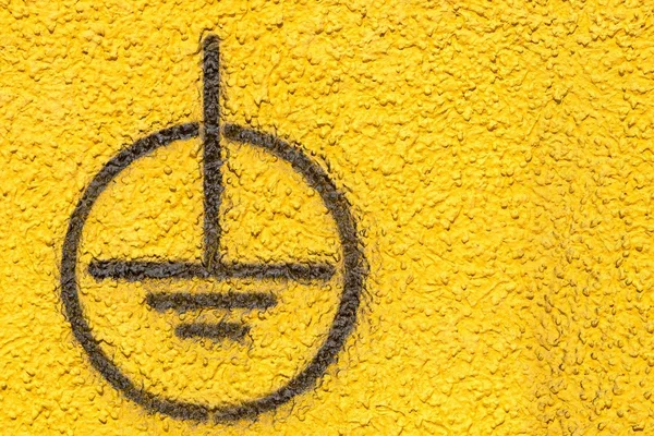 Grounding sign on the yellow plastered wall — Stock Photo, Image