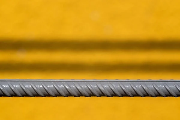 Gray rod of fittings on a yellow background — Stock Photo, Image