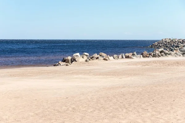 Zandige kust van de zee met horizon en stenen — Stockfoto