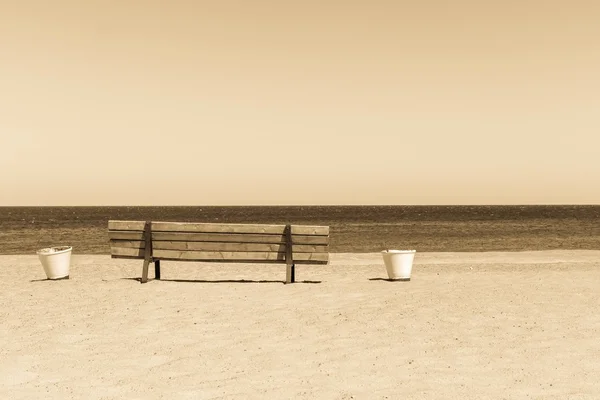 Houten sepia Bank aan de kust van het zandstrand — Stockfoto