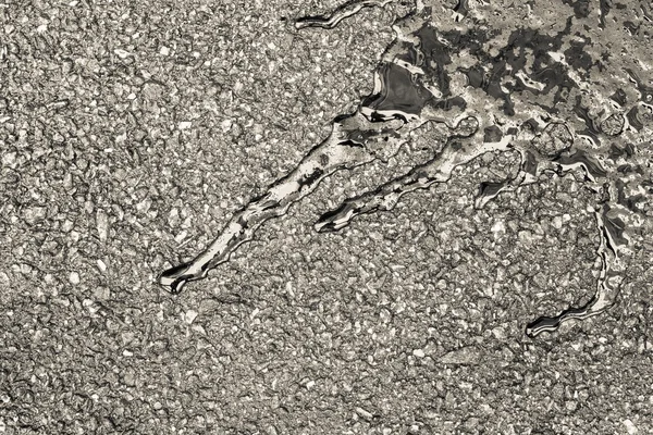 Bitumen abstracte vorm op vochtige asfalt van beige kleur — Stockfoto