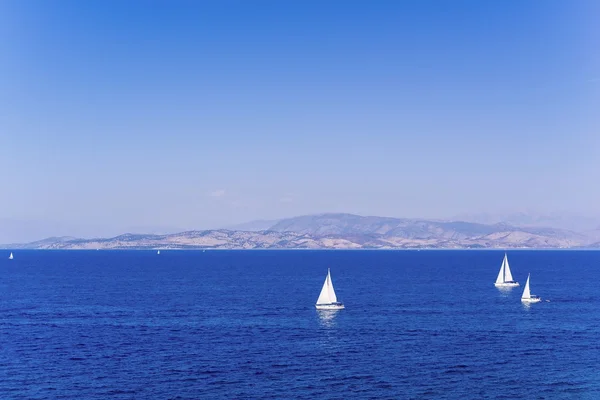 Paisagem do mar com iates e um maciço no horizonte — Fotografia de Stock