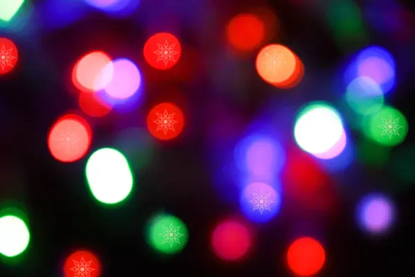 Luzes de Natal multicoloridas brilhantes bokeh e padrão de floco de neve — Fotografia de Stock