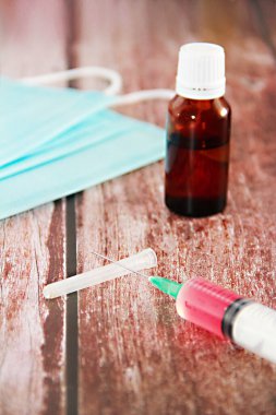 Aşı ve mavi tıbbi maskeli bir şırınga.