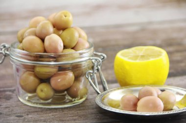 Cam kavanozda yeşil tuzlanmış zeytin.