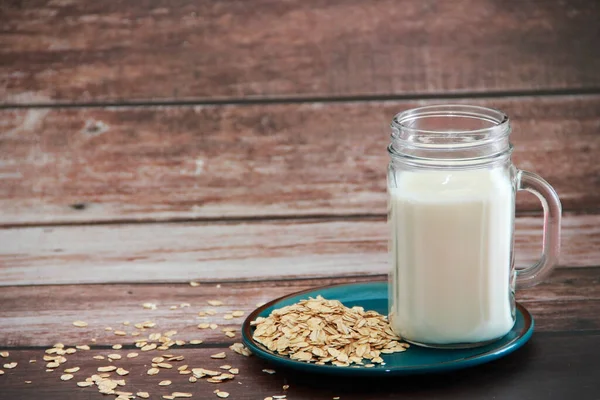 Cam bardakta beyaz süt kefir ve kuru yulaf lapası.