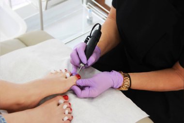 Eldivenli ustanın elleri pedikür yapıyor.