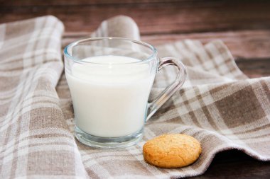 Bardakta beyaz süt ve kurabiye.