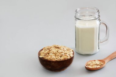 Kupada beyaz süt ve kuru yulaf lapası.